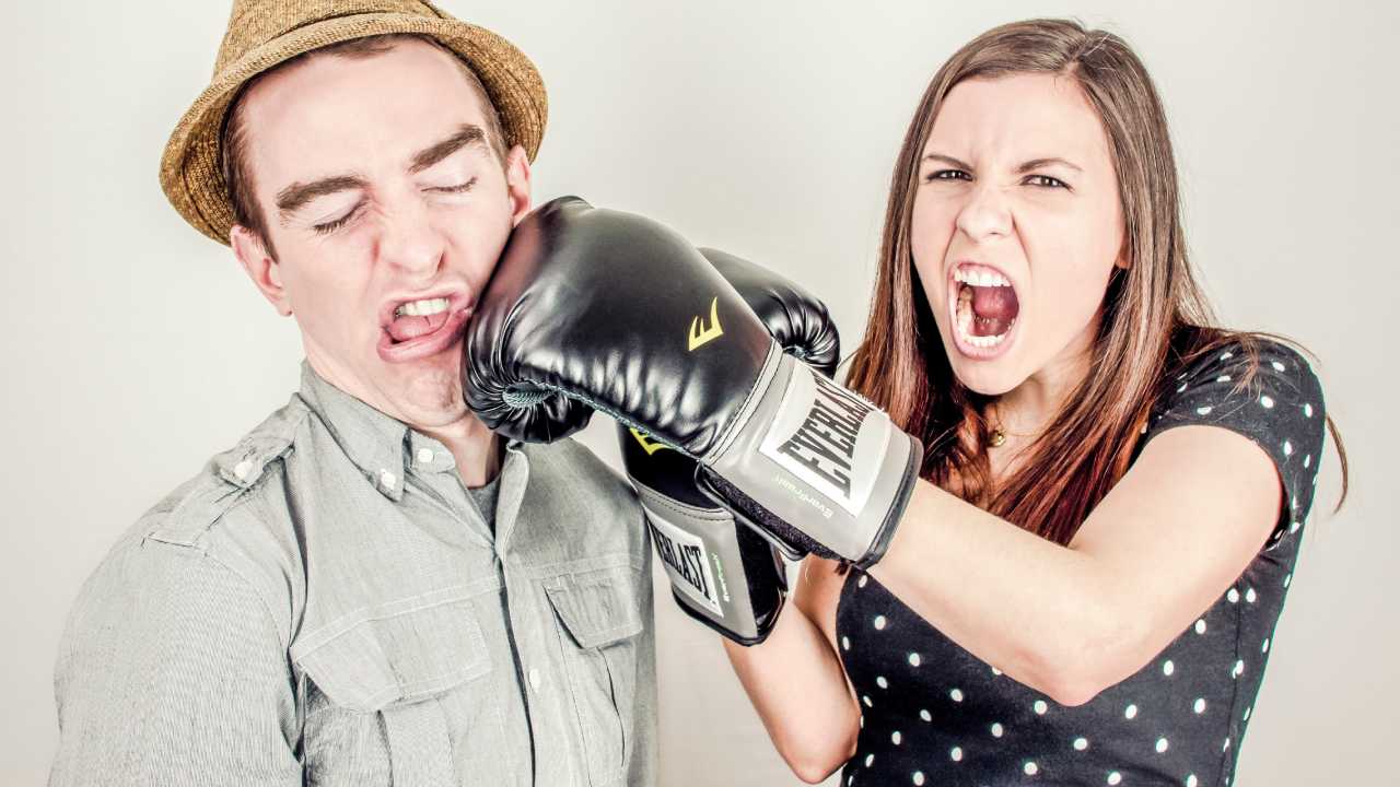 Girl full of aggression punches a man.